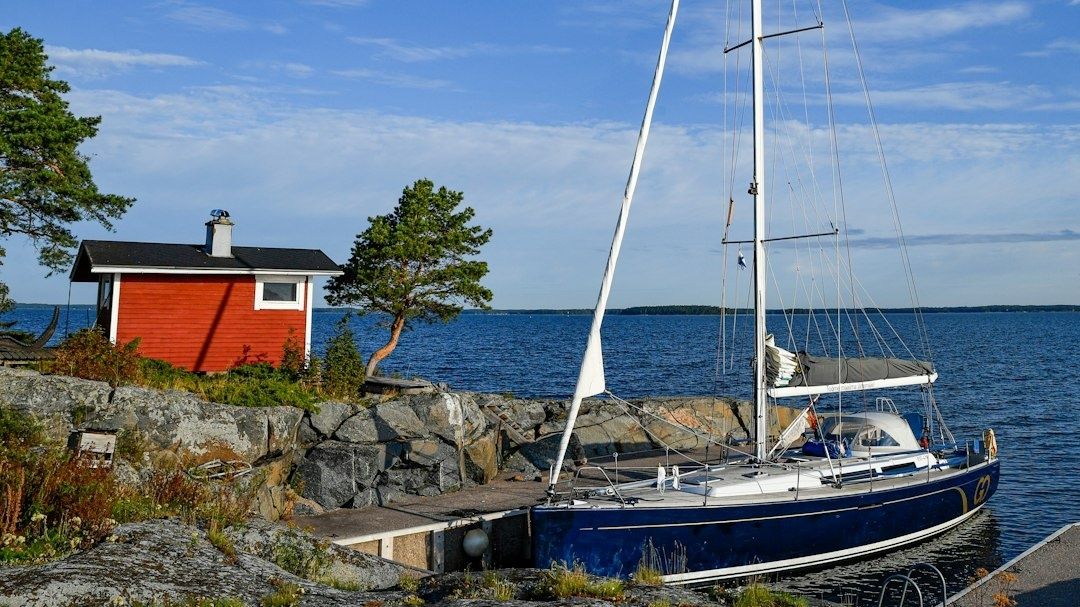 Segelbåt förtöjd vid brygga i ett trångt skärgårdssund